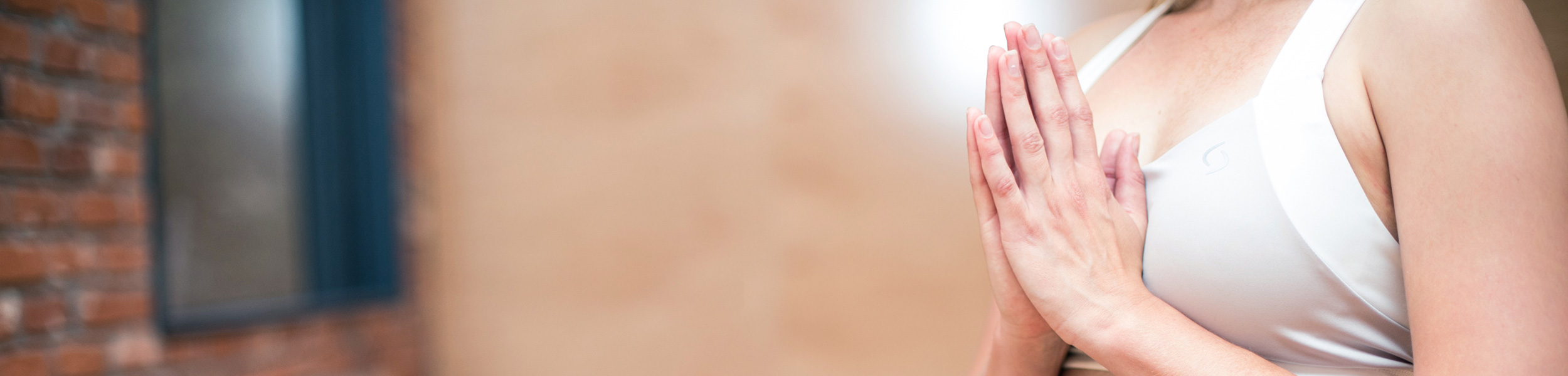 Eine Frau welche die Hände zusammengefaltet vor sich hat